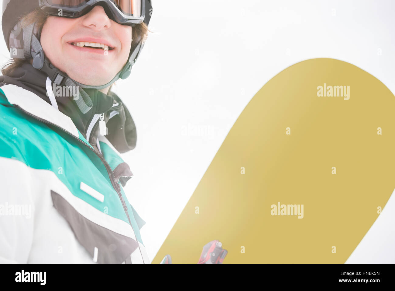 Smiling young man holding snowboard Stock Photo