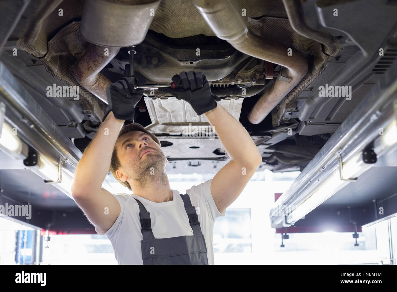 Mid adult automobile mechanic repairing car in workshop Stock Photo