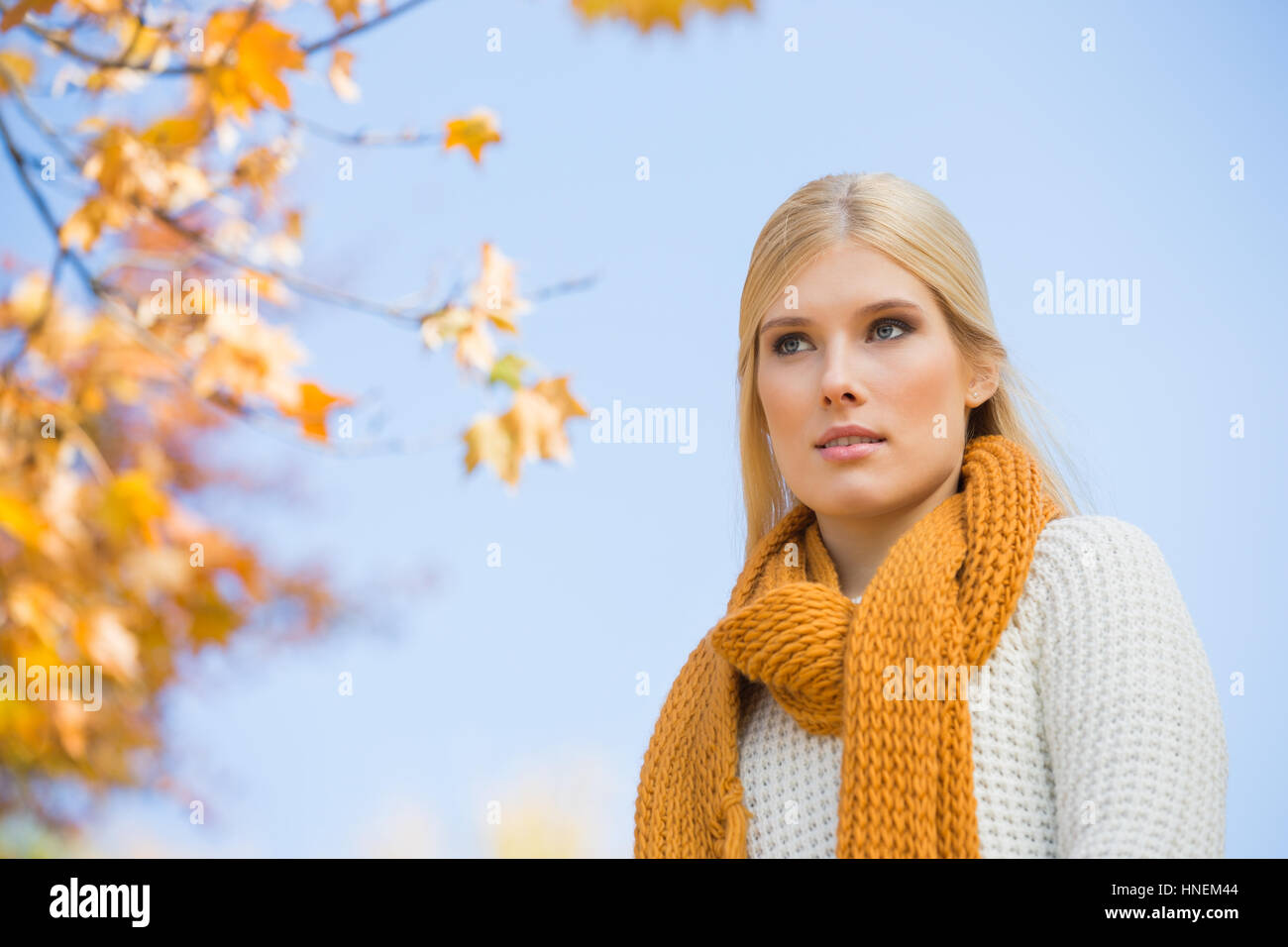 Low angle view of thoughtful young woman against sky Stock Photo