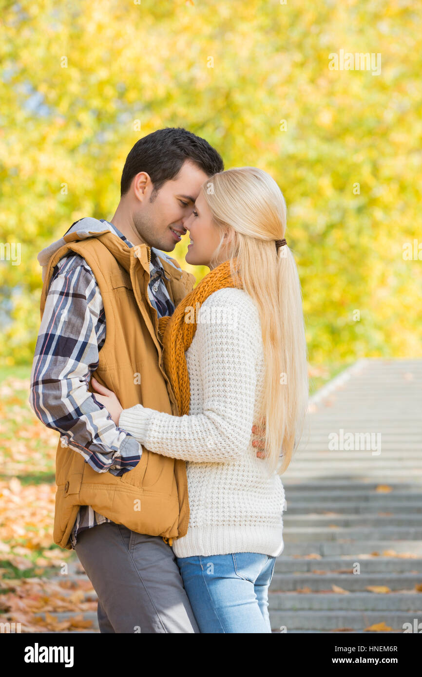 Couple kissing in park during autumn Stock Photo