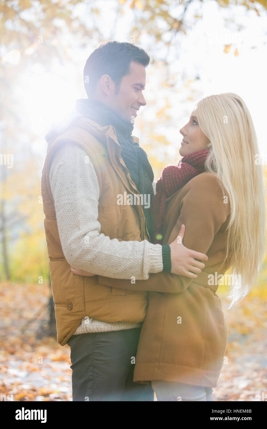 Side view of couple hugging in park Stock Photo