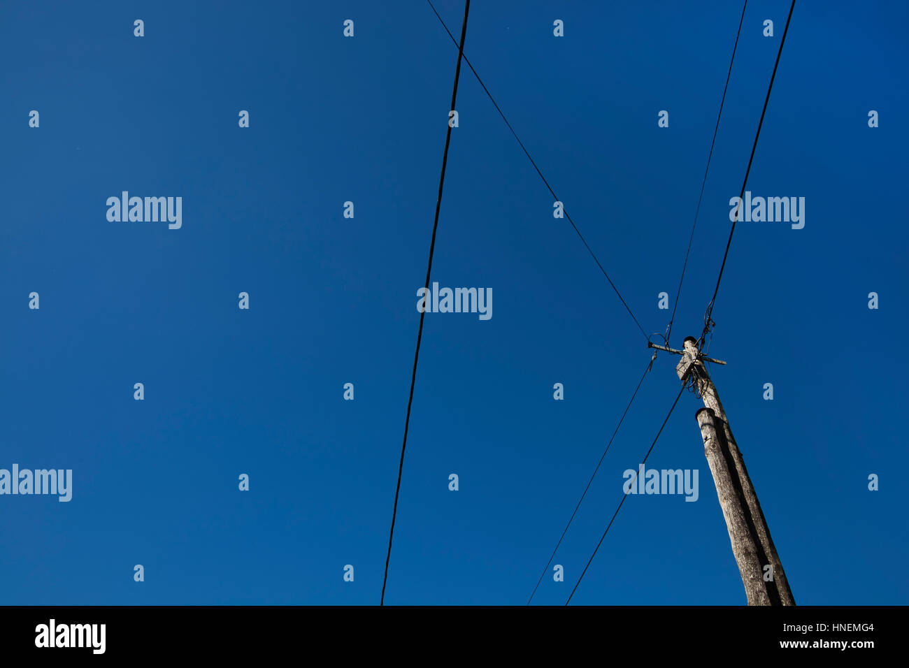 Low angle view of electric wires against clear blue sky Stock Photo