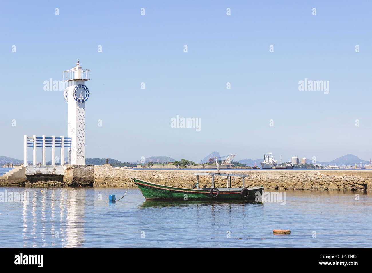 Brazil, State of Rio de Janeiro, Paqueta Island, View of bird on top of a fishing boat close to the lighthouse Stock Photo