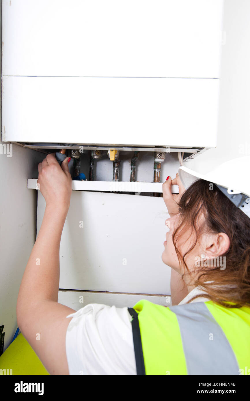 Female plumber servicing central heating boiler Stock Photo