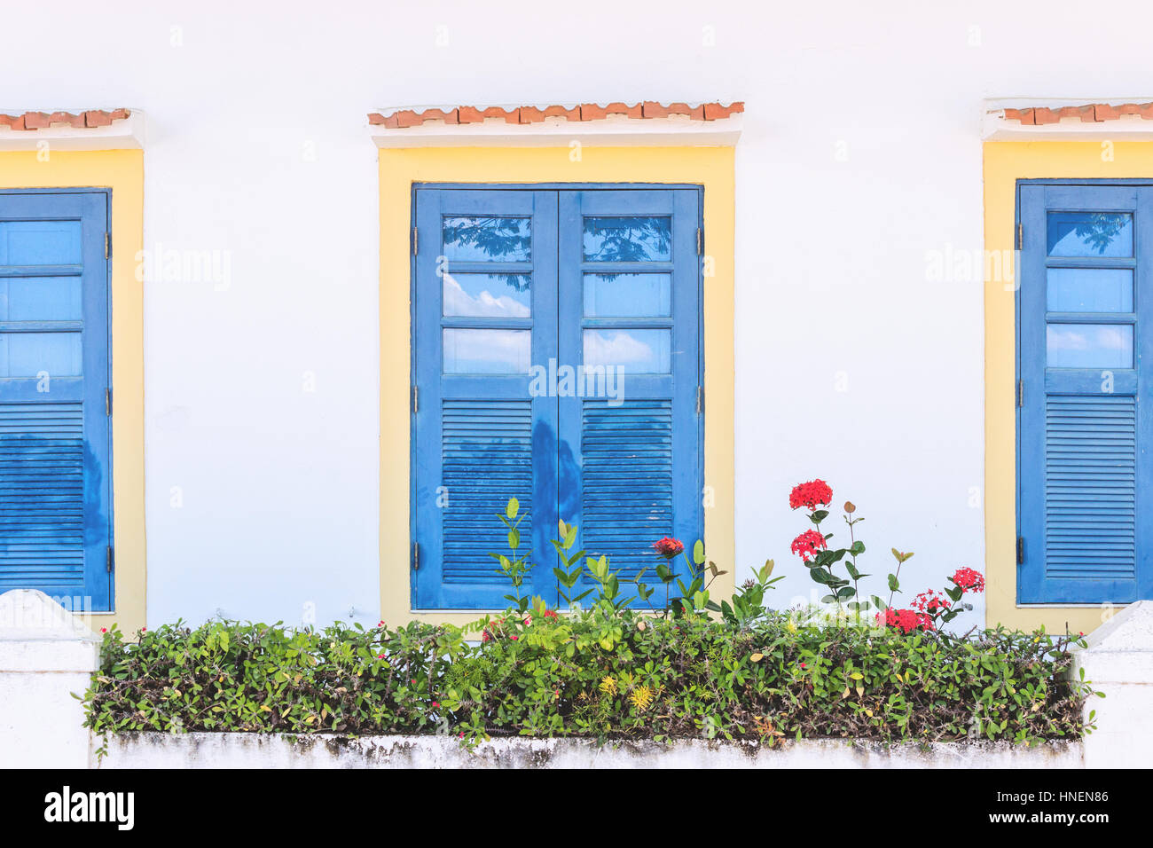 Brazil, State of Rio de Janeiro, Paqueta Island, Facade of colonial style house with blue colorful windowns under bright light Stock Photo