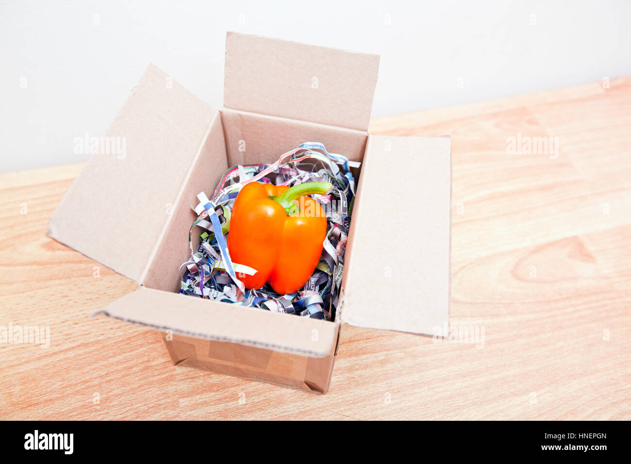 Orange bell pepper wrapped up in a box Stock Photo