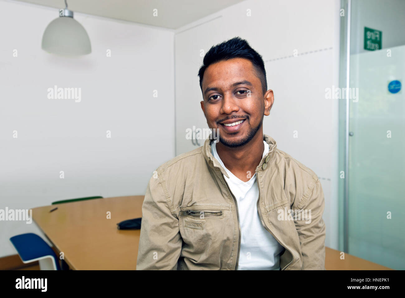 Young Indian man smiling at camera in his office Stock Photo