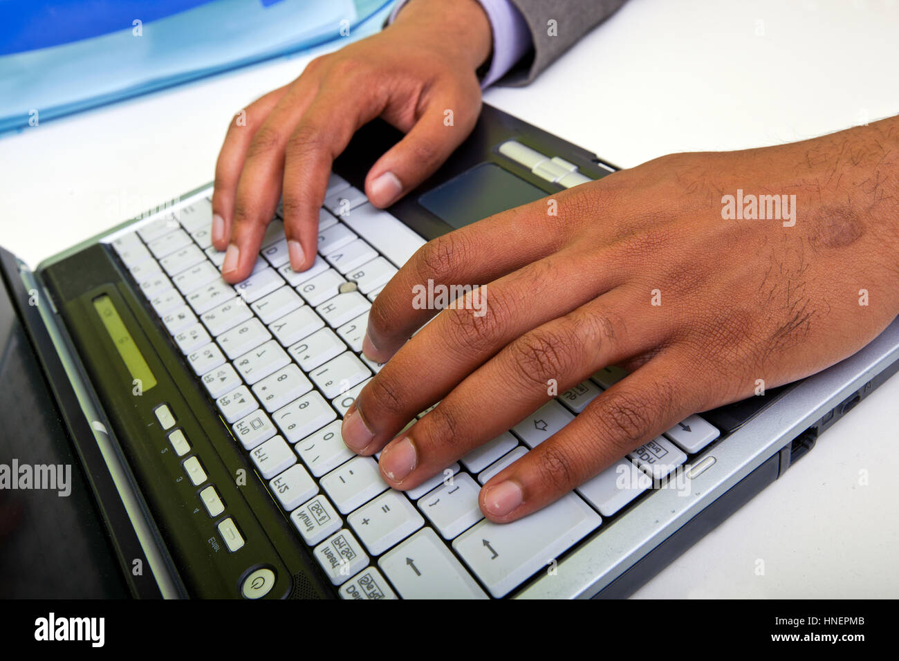 Close up of Indian mans hands typing on laptop Stock Photo