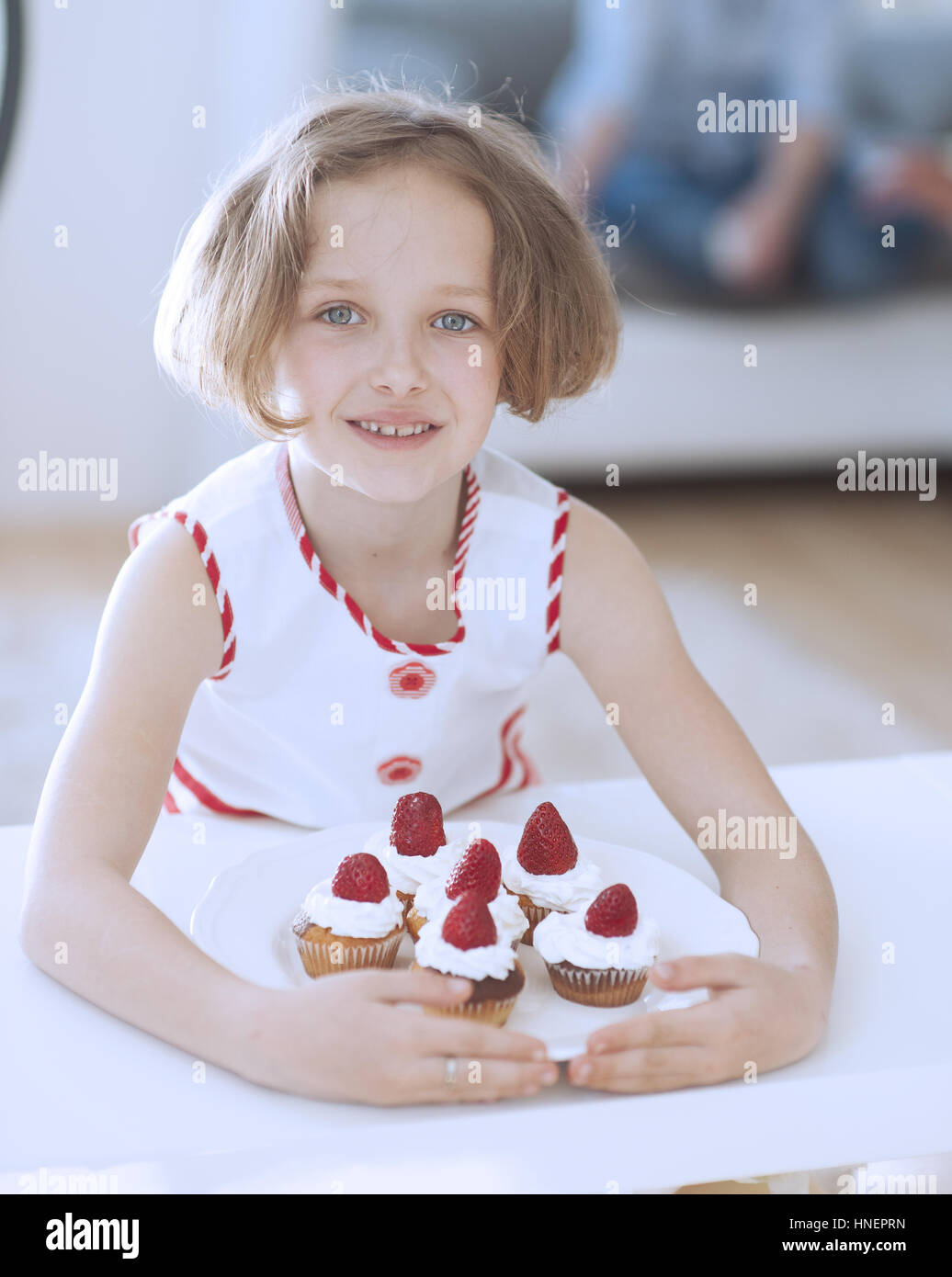Young girl with plate of cupcakes Stock Photo