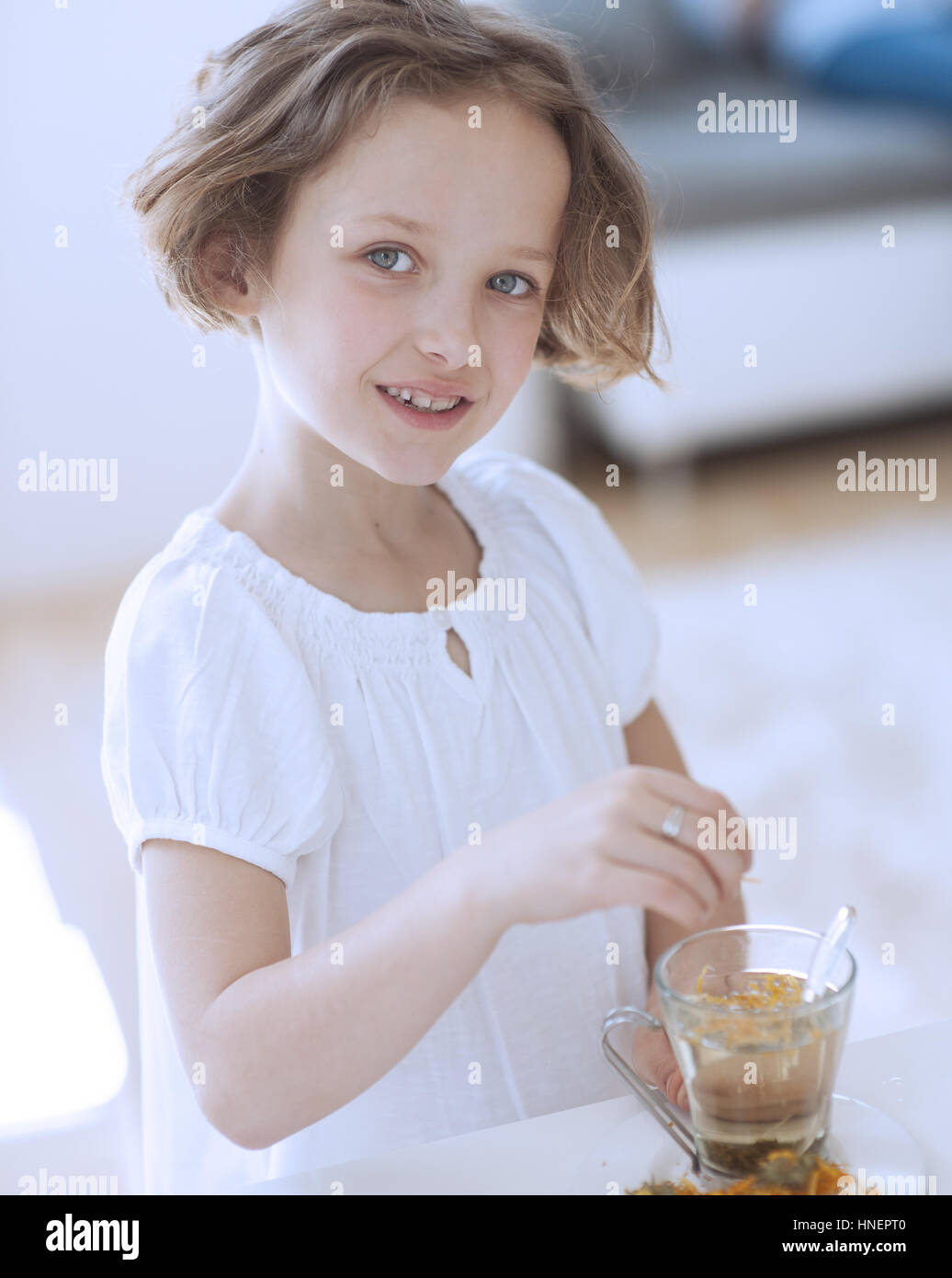 Young girl with cup of tea and flowers Stock Photo
