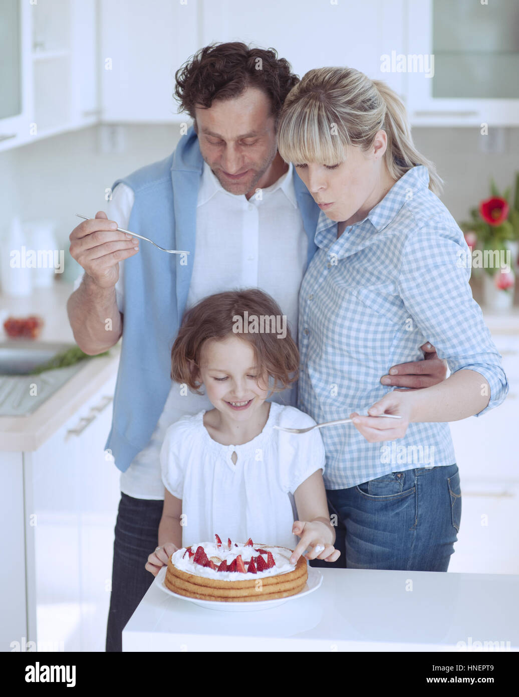 Family preparing healthy meal in kitchen Stock Photo