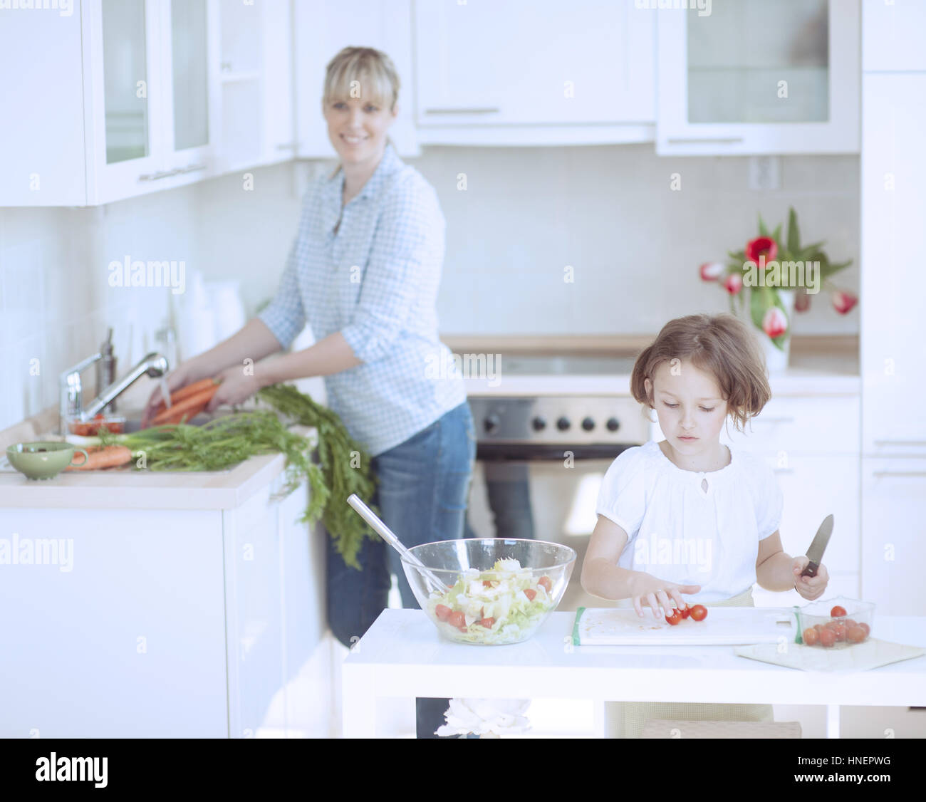 Mother and Daughter (8-9) preparing healthy meal in kitchen Stock Photo