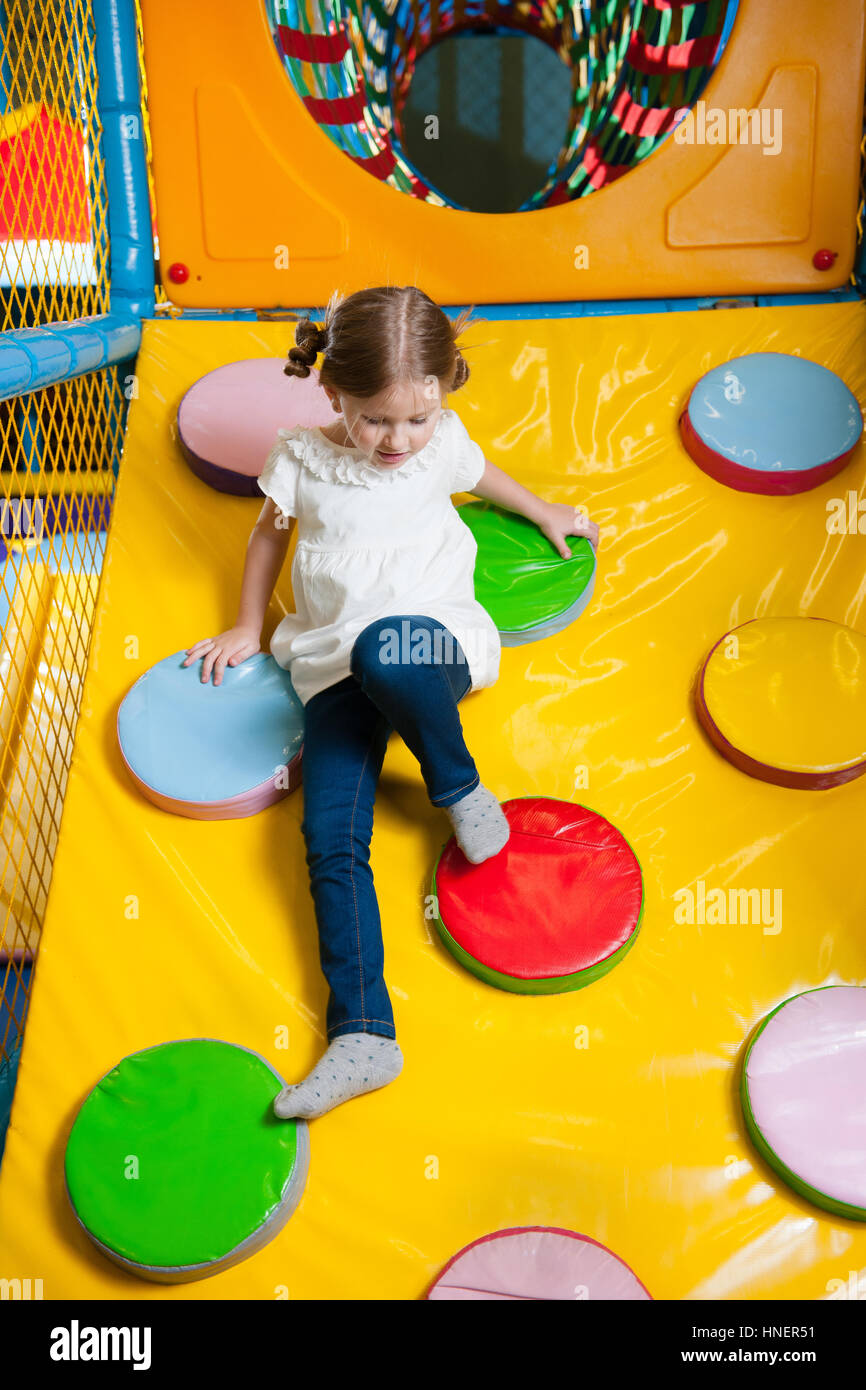 Young girl climbing down ramp in soft play centre Stock Photo - Alamy