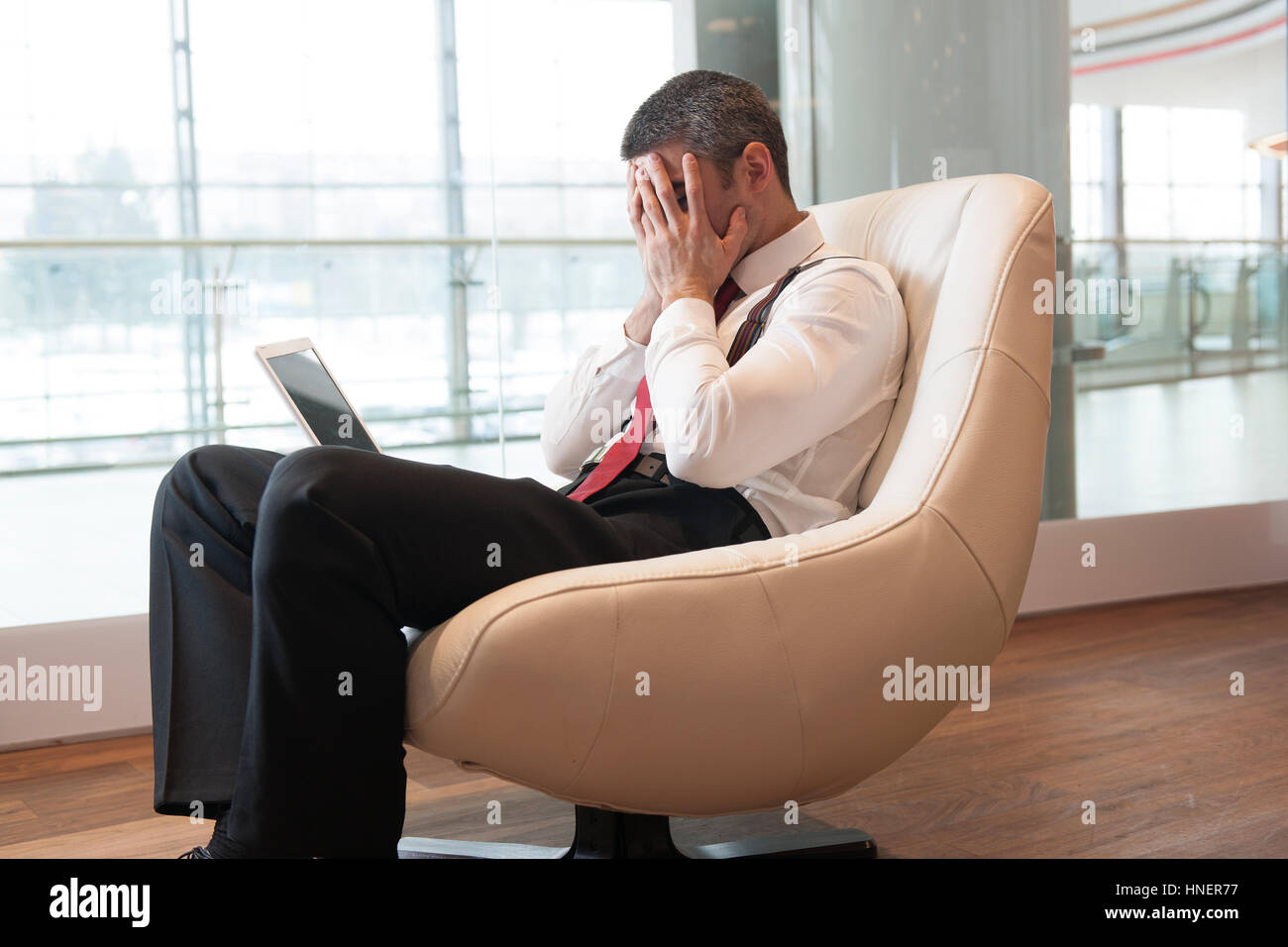 Stressed out businessman covers face with hands Stock Photo