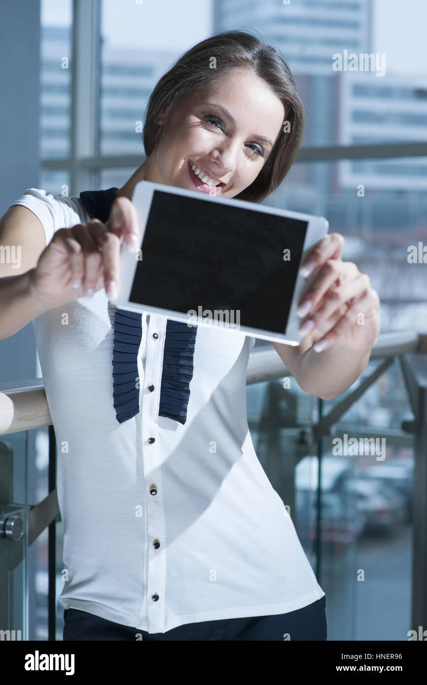 Businesswoman holds up tablet device to camera Stock Photo