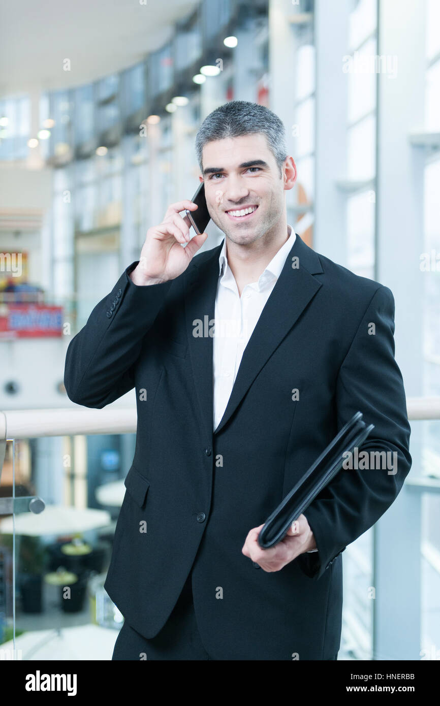 Businessman on mobile phone looking at camera Stock Photo