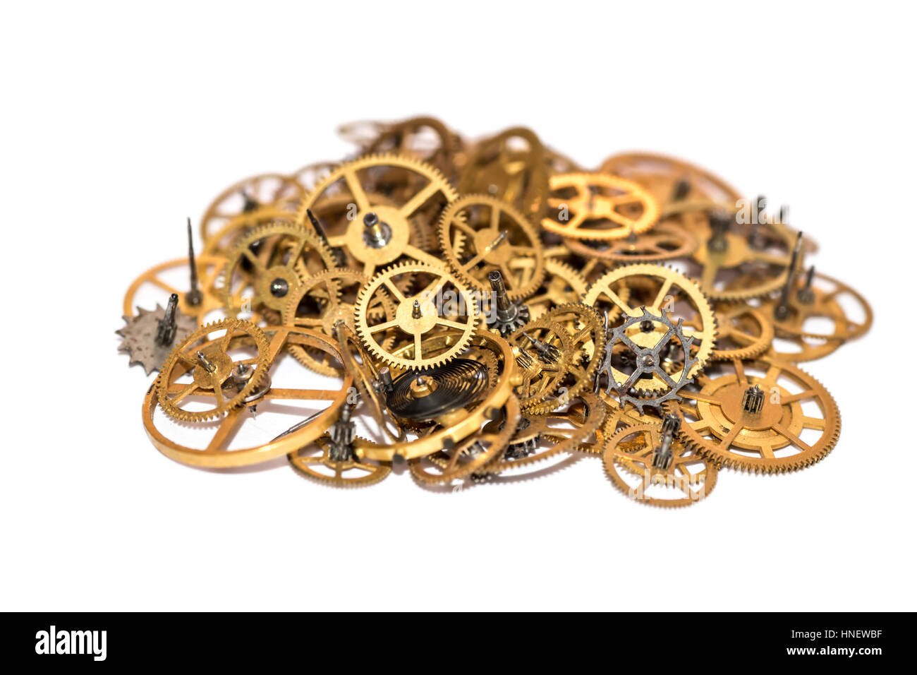 A pile of gear. Many mechanisms. Old vintage gears. Part of clockwork. The natural color and texture. Focus on front, blurred background. Golden cogs. Stock Photo
