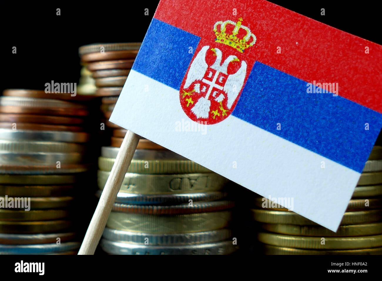 Serbia flag waving with stack of money coins macro Stock Photo