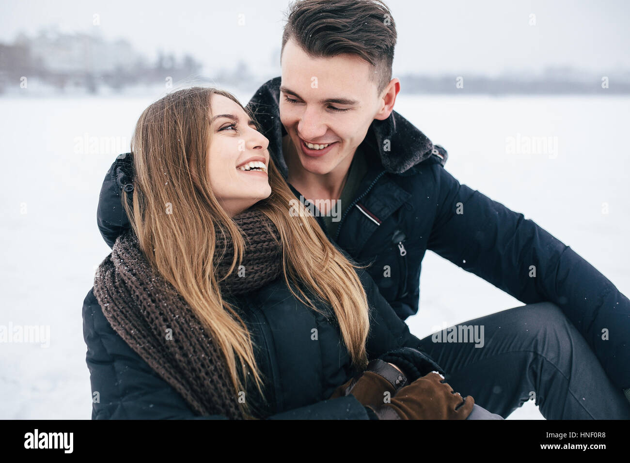 couple sitting on the snow Stock Photo - Alamy