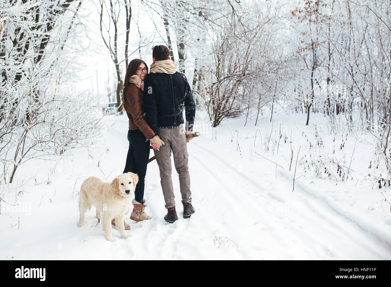 Young couple in love walking with dog Stock Photo - Alamy