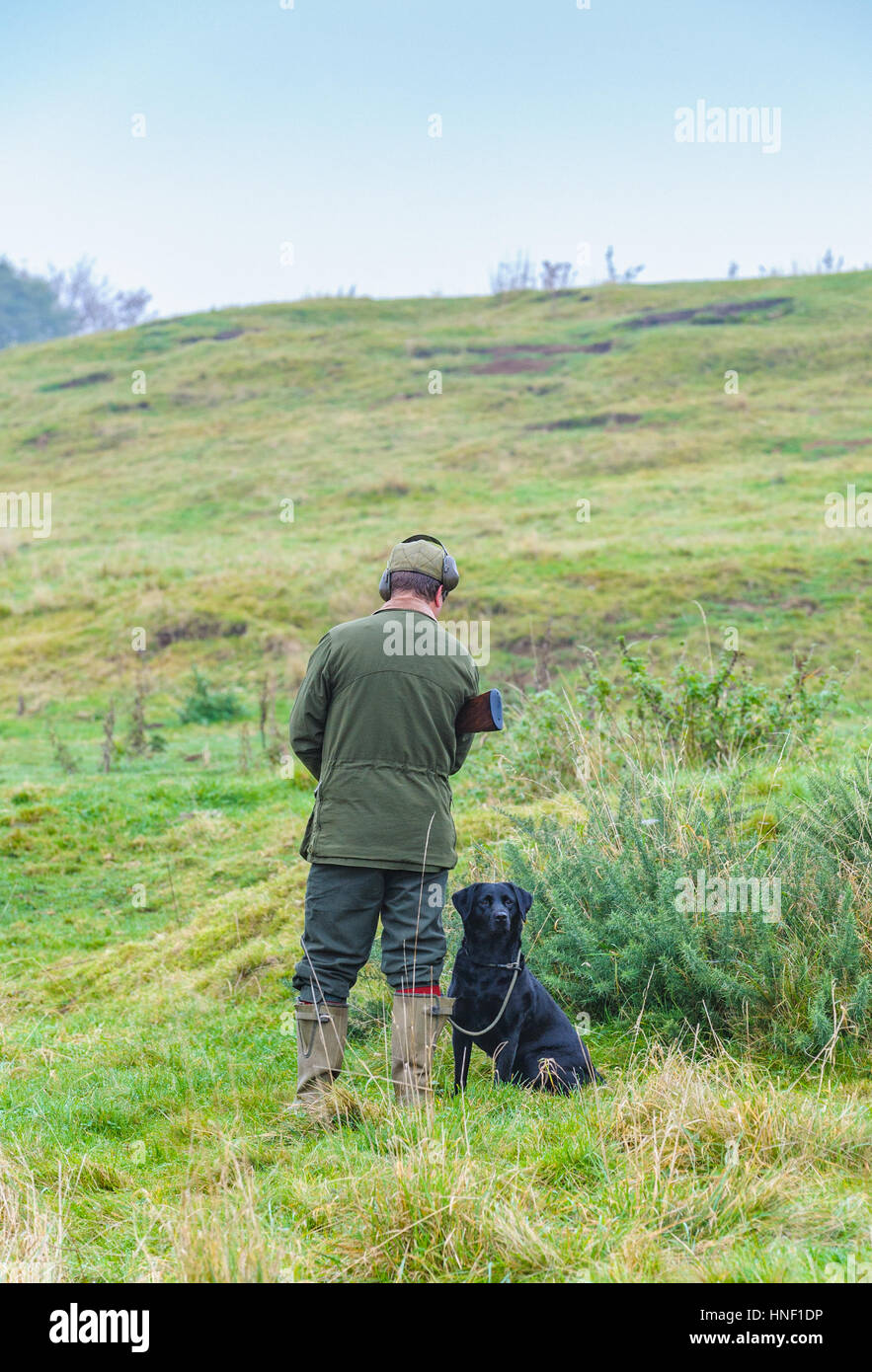 A man with a black Labrador dog on a days shooting Stock Photo