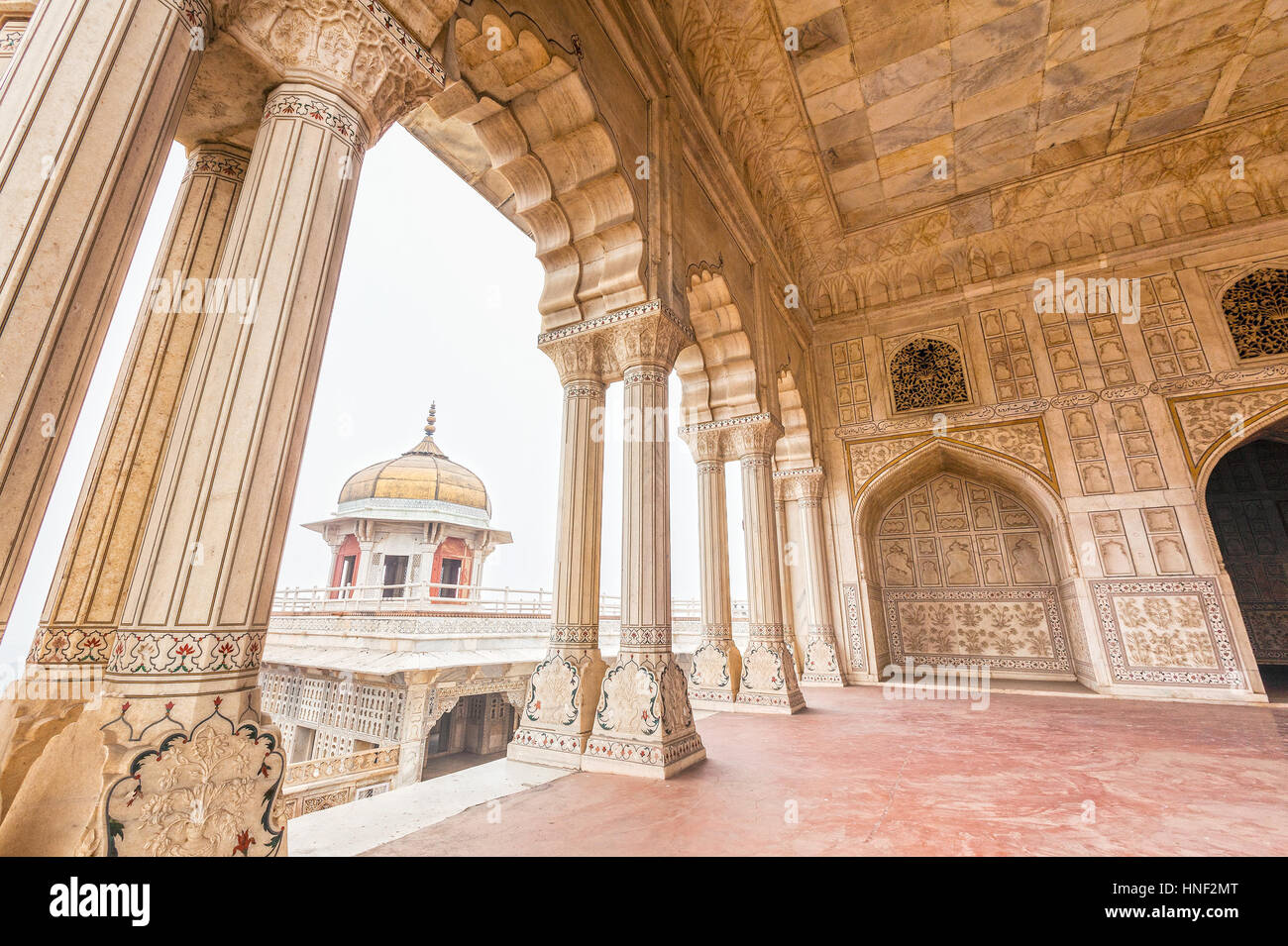 Highly decorated marble interior of Diwan-e-Khas, 'The Hall of Private Audiences' at Agra Fort. The octagonal tower of Musamman Burj can be seen throu Stock Photo