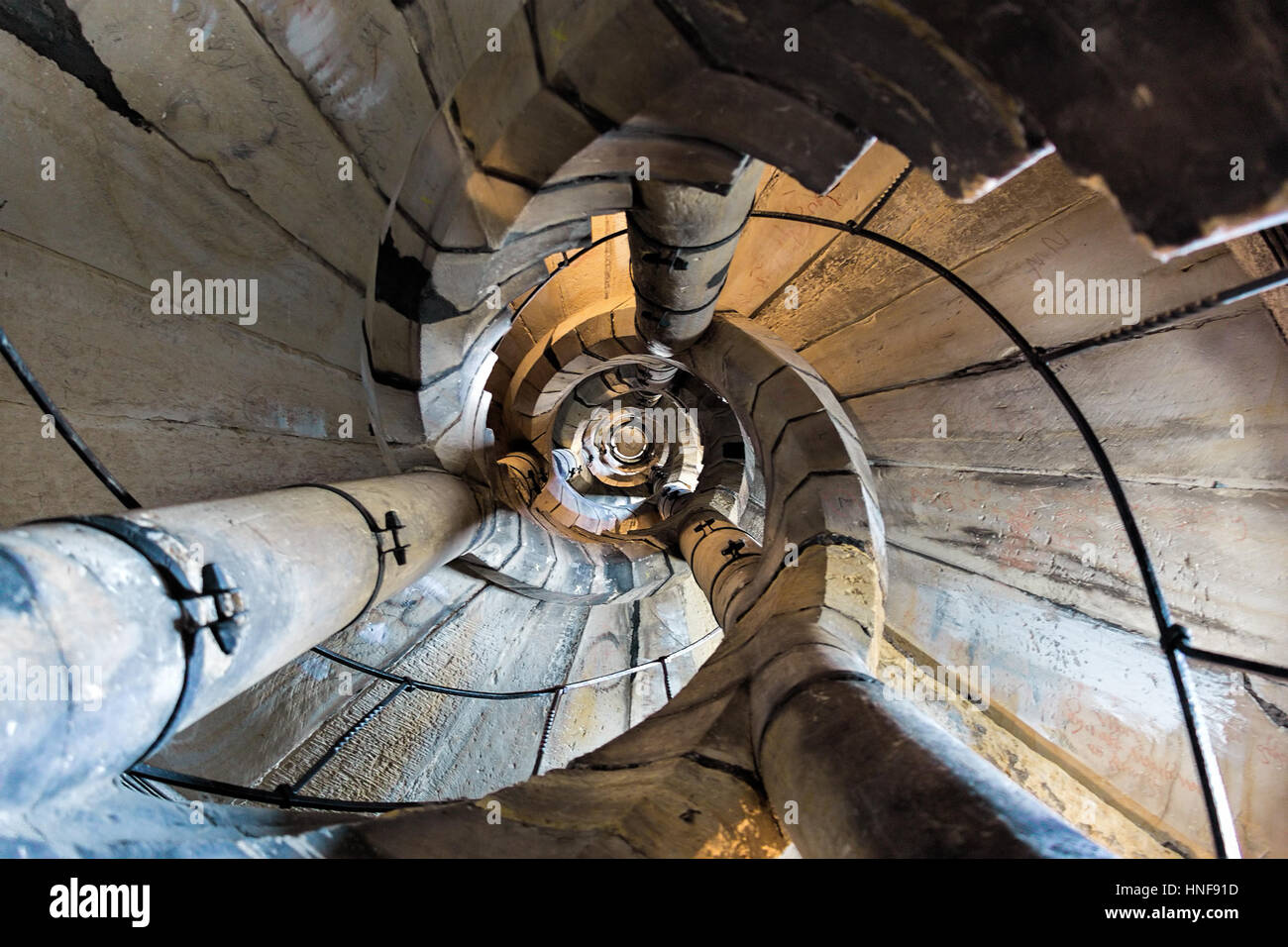 Downwards view of spiral stone stairs of old tower of gothic historic church. Stock Photo