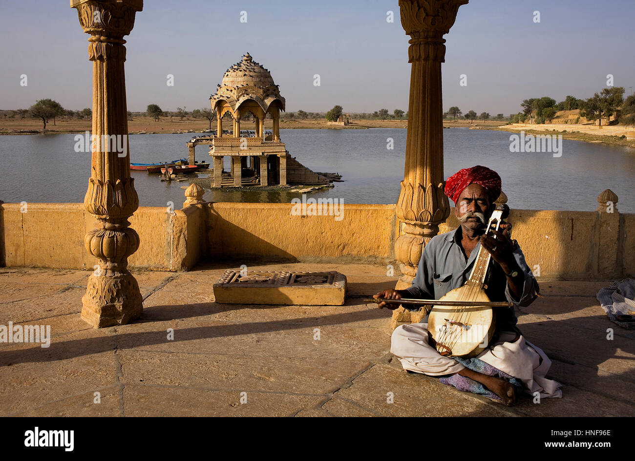 Busker, musician, Gadi Sagar, the tank was once the water supply of the city and is surrounded by small temples and shrines, Jaisalmer,Rajasthan,India Stock Photo