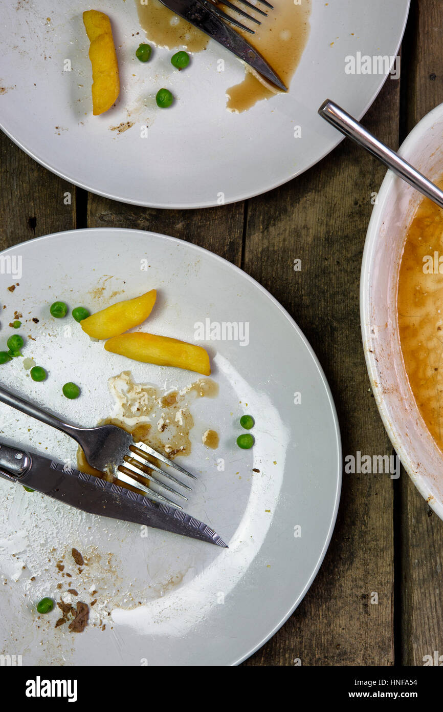 Overhead shot of an empty plate with leftovers from a meal on a rustic wooden backround Stock Photo