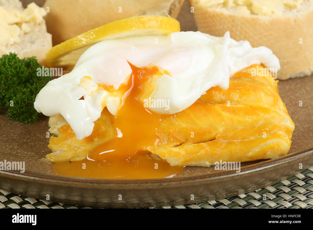poached smoked haddock with egg and crusty bread Stock Photo Alamy