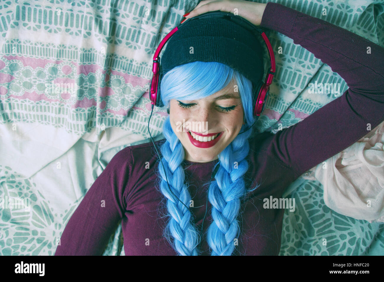 Alternative teenager with blue hair listenig to music Stock Photo