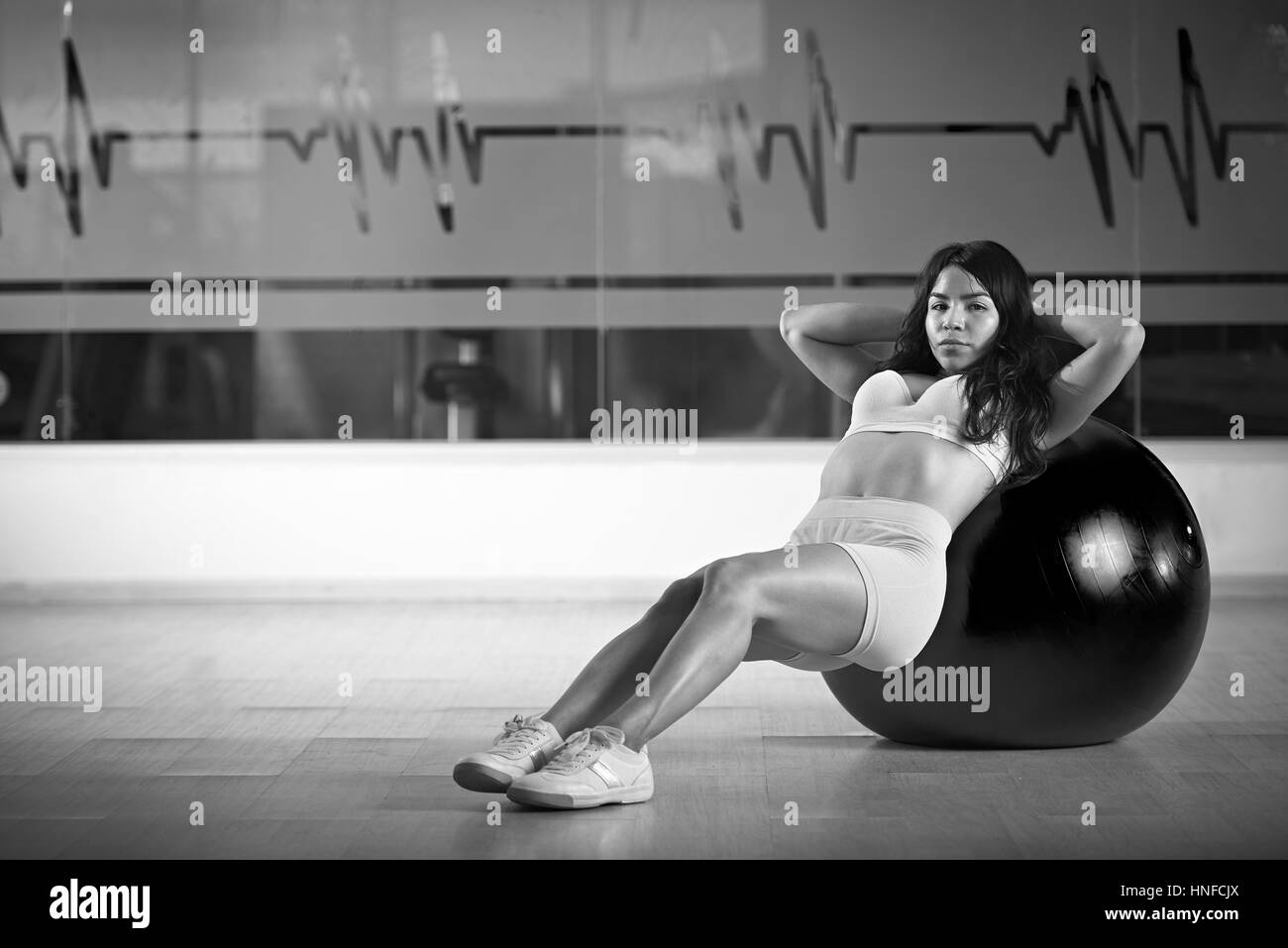 Trainer young woman show exercise in gym black and white colours Stock Photo