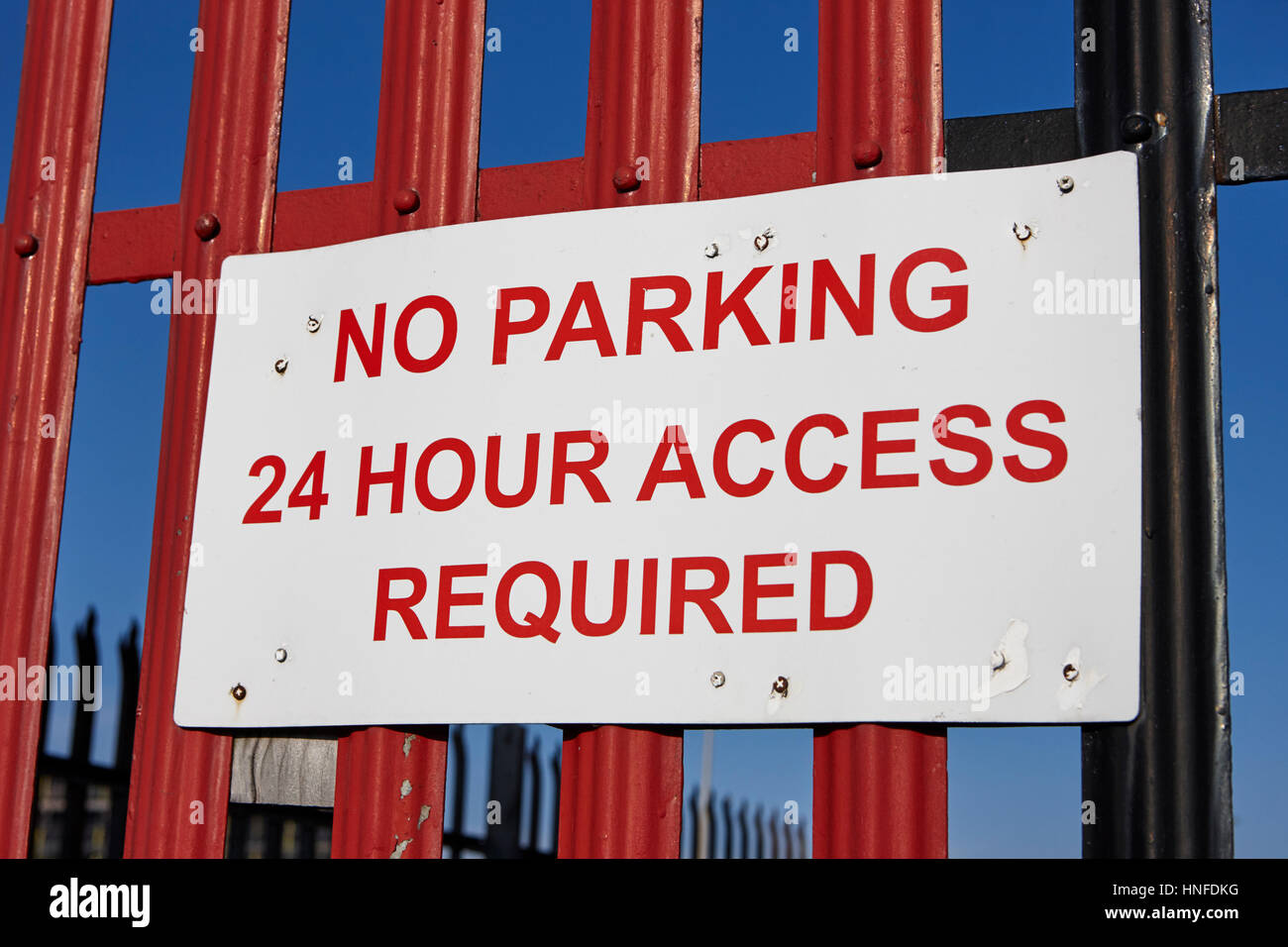 no parking sign 24 hour access required on a fence in the uk Stock Photo