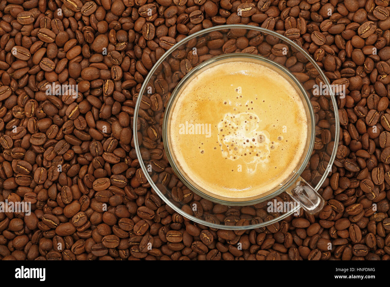 Full latte cappuccino with milk froth in big transparent glass cup with