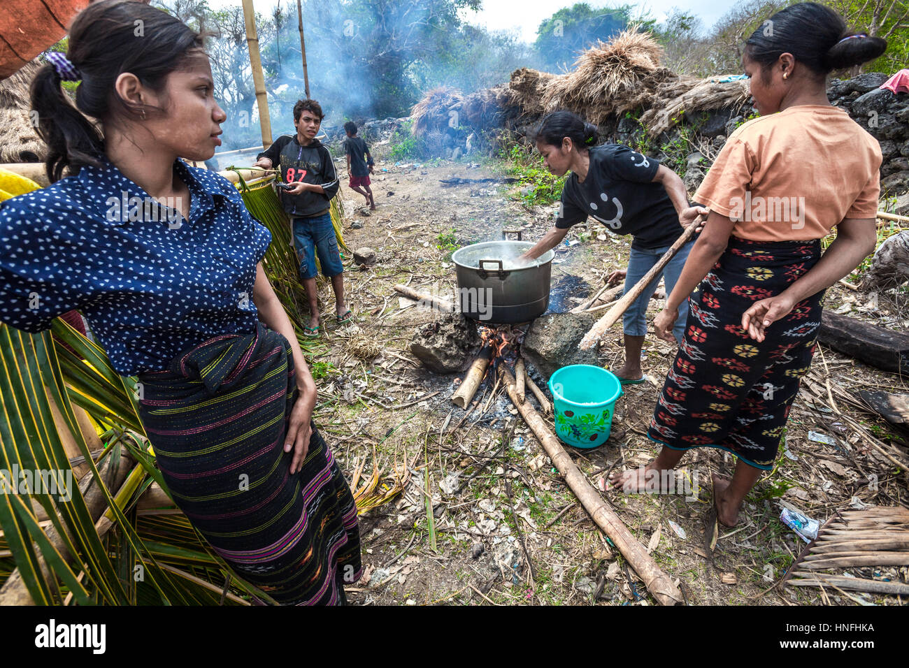 Women boiling water as a preparation for a ritual of house construction and inauguration in Ratenggaro, Southwest Sumba, East Nusa Tenggara, Indonesia. Stock Photo