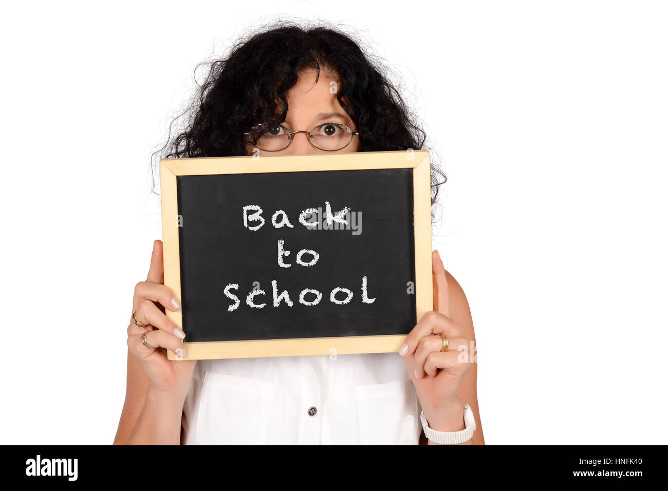 Portrait of beautiful school teacher holding chalkboard with text 'Back to school'. Education concept. Isolated white background. Stock Photo