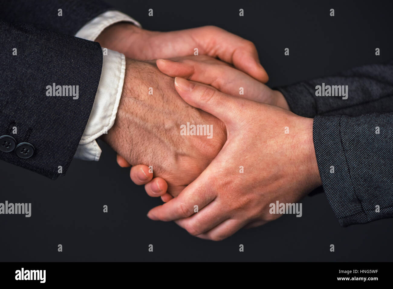 Businessman and businesswoman handshake in office, people greeting each other at business meeting, close up of hands Stock Photo
