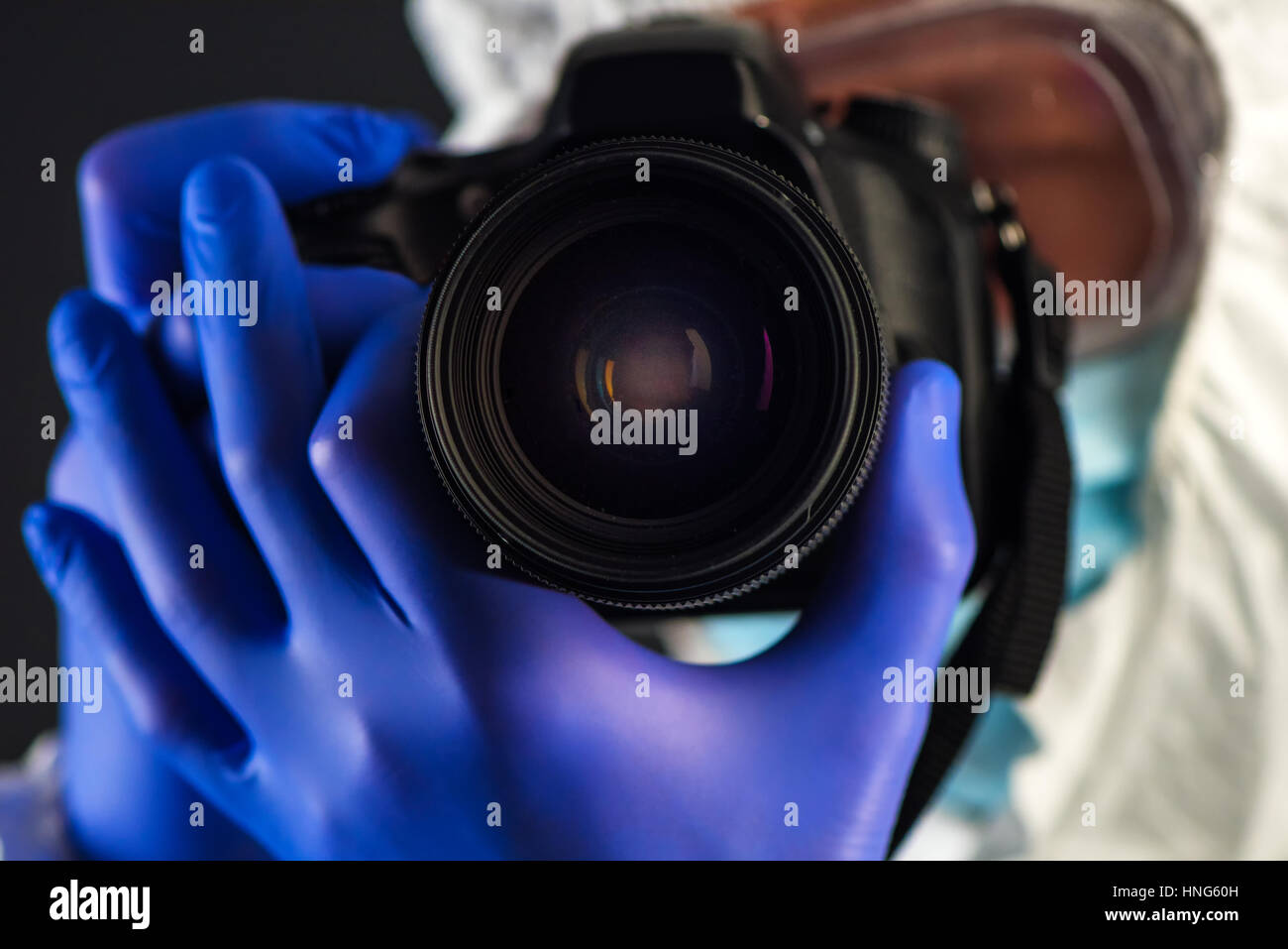 Crime scene forensics investigator with digital camera taking pictures as evidence for the investigation Stock Photo