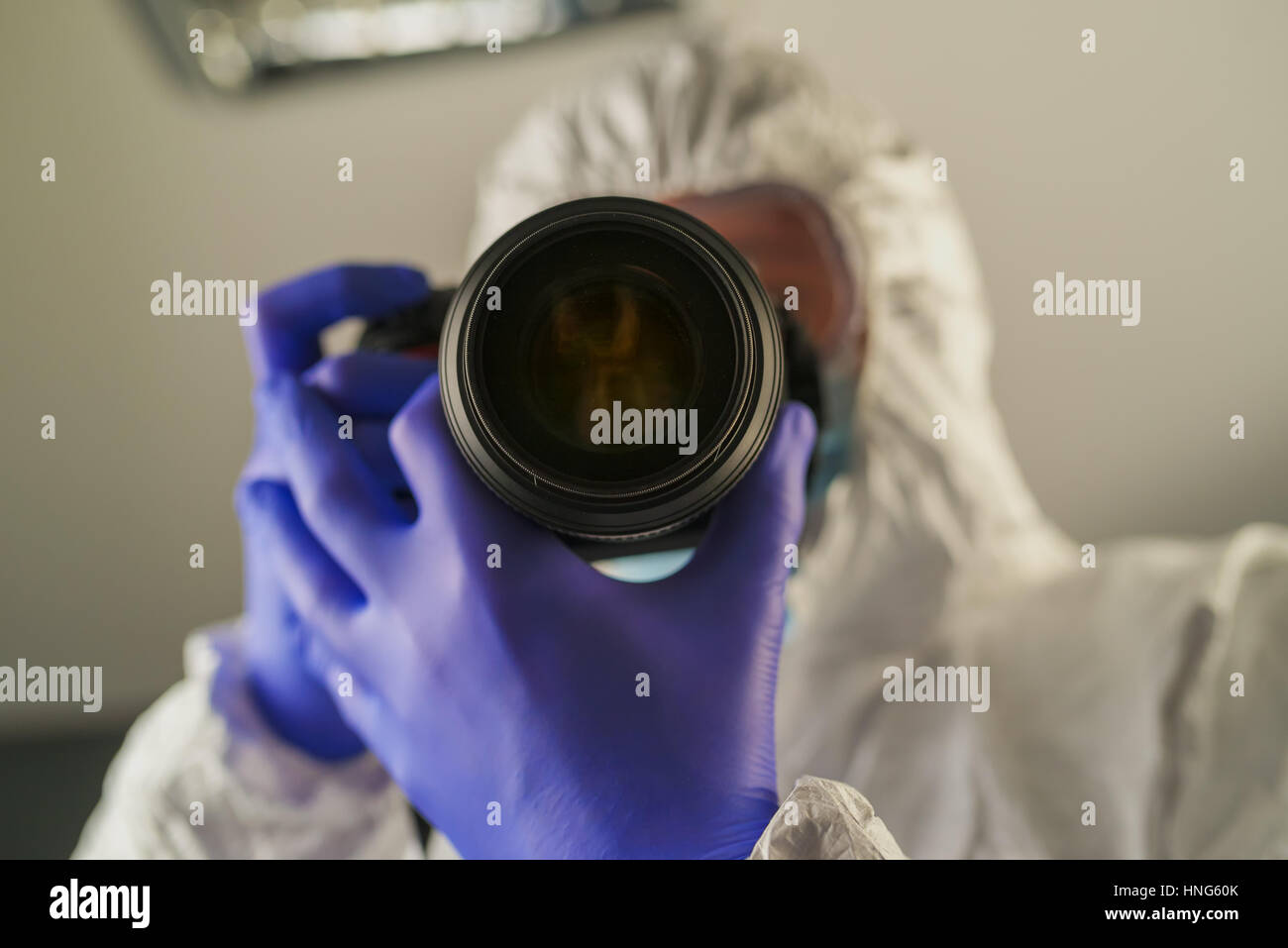 Crime scene forensics investigator with digital camera taking pictures as evidence for the investigation Stock Photo