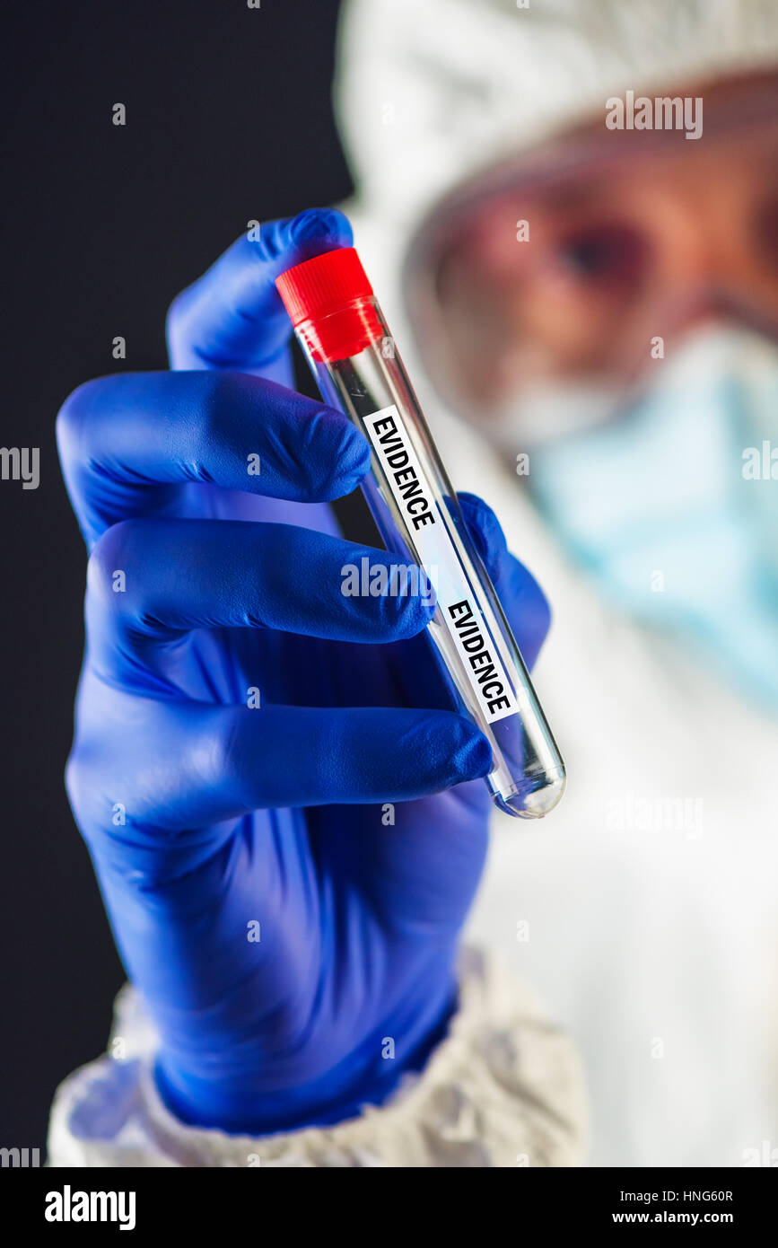 Forensic scientist with evidence tube during crime scene investigation Stock Photo