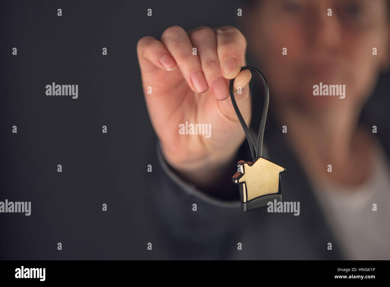 Female real estate agent with house model key ring, selective focus Stock Photo