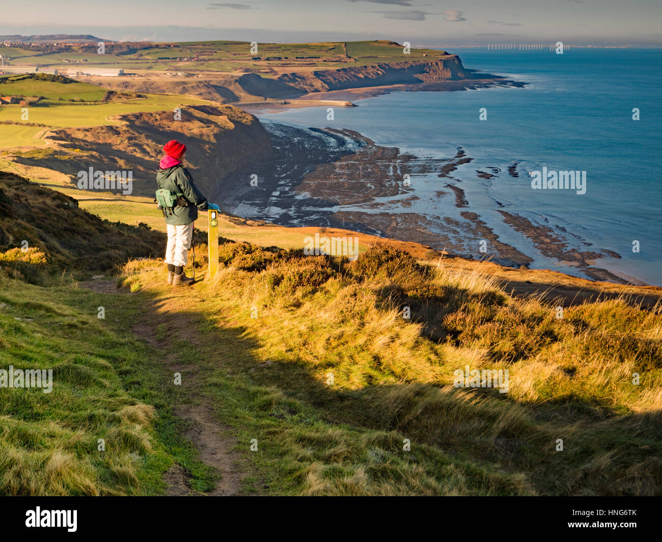 Elderly Female walker on the Cleveland Way taking in the view over Tees Bay from above Hummersea Scars Stock Photo