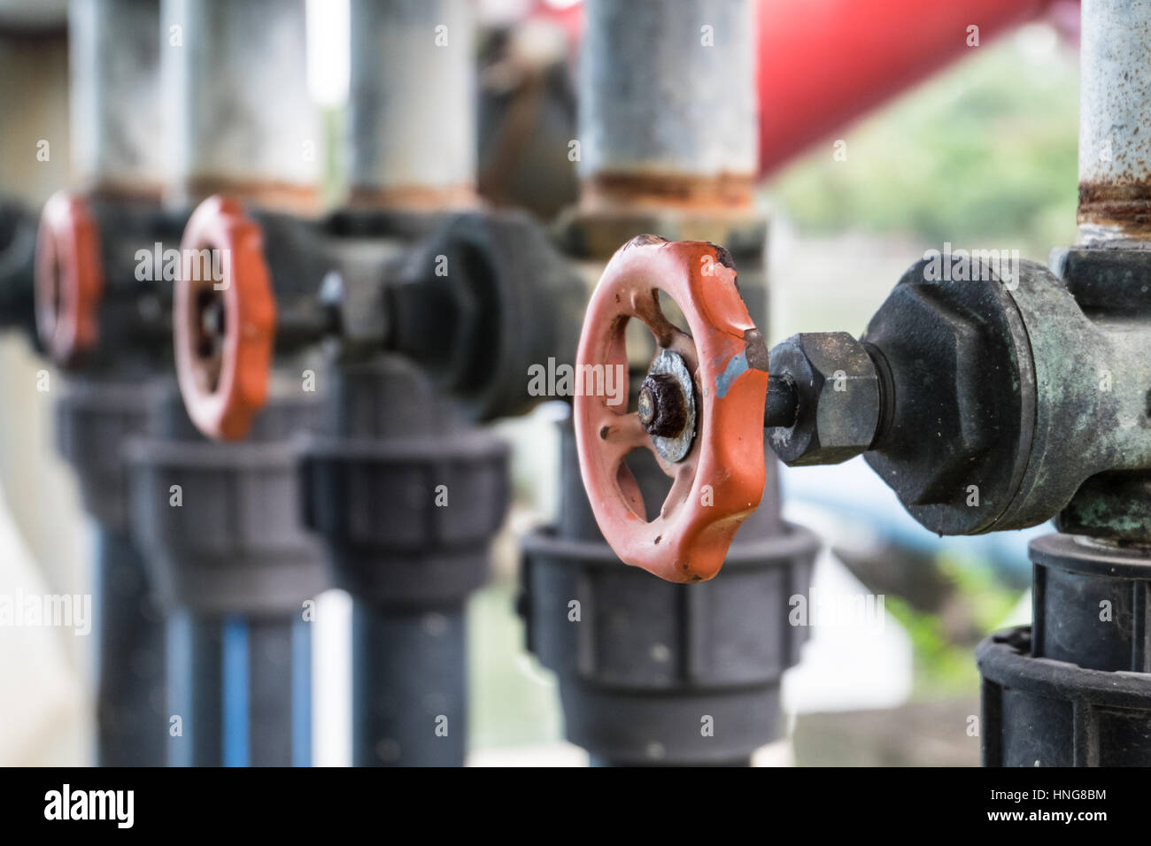 Old water valve and pipe connect from pump into the lake within public