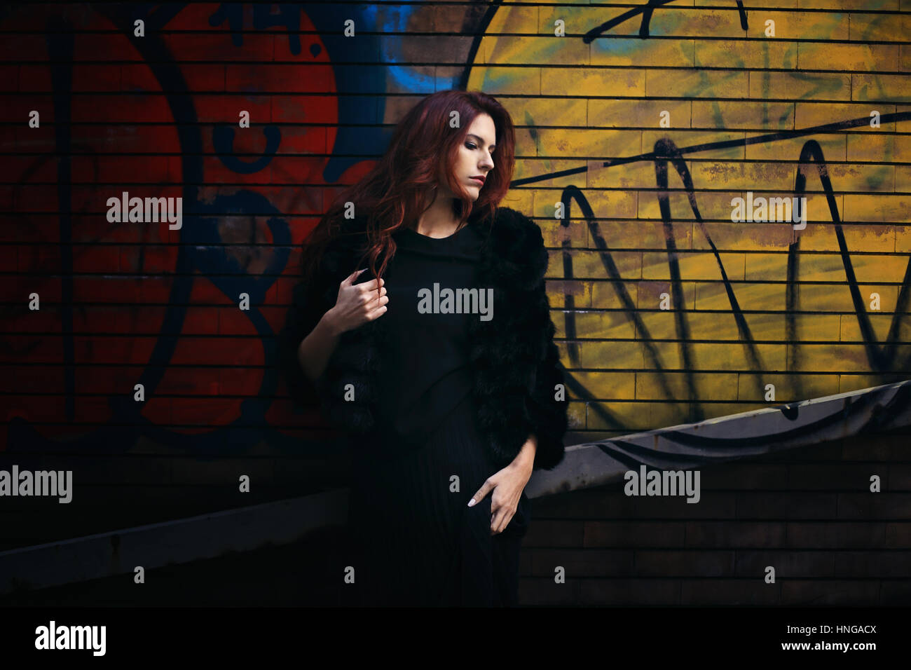 Fashion woman against wall painting background . Street and urban Stock Photo