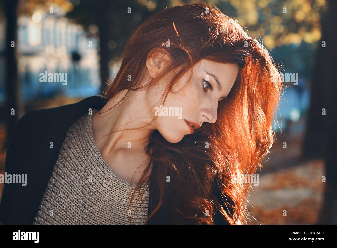 Autumn portrait of a beautiful red haired woman. City and urban Stock Photo