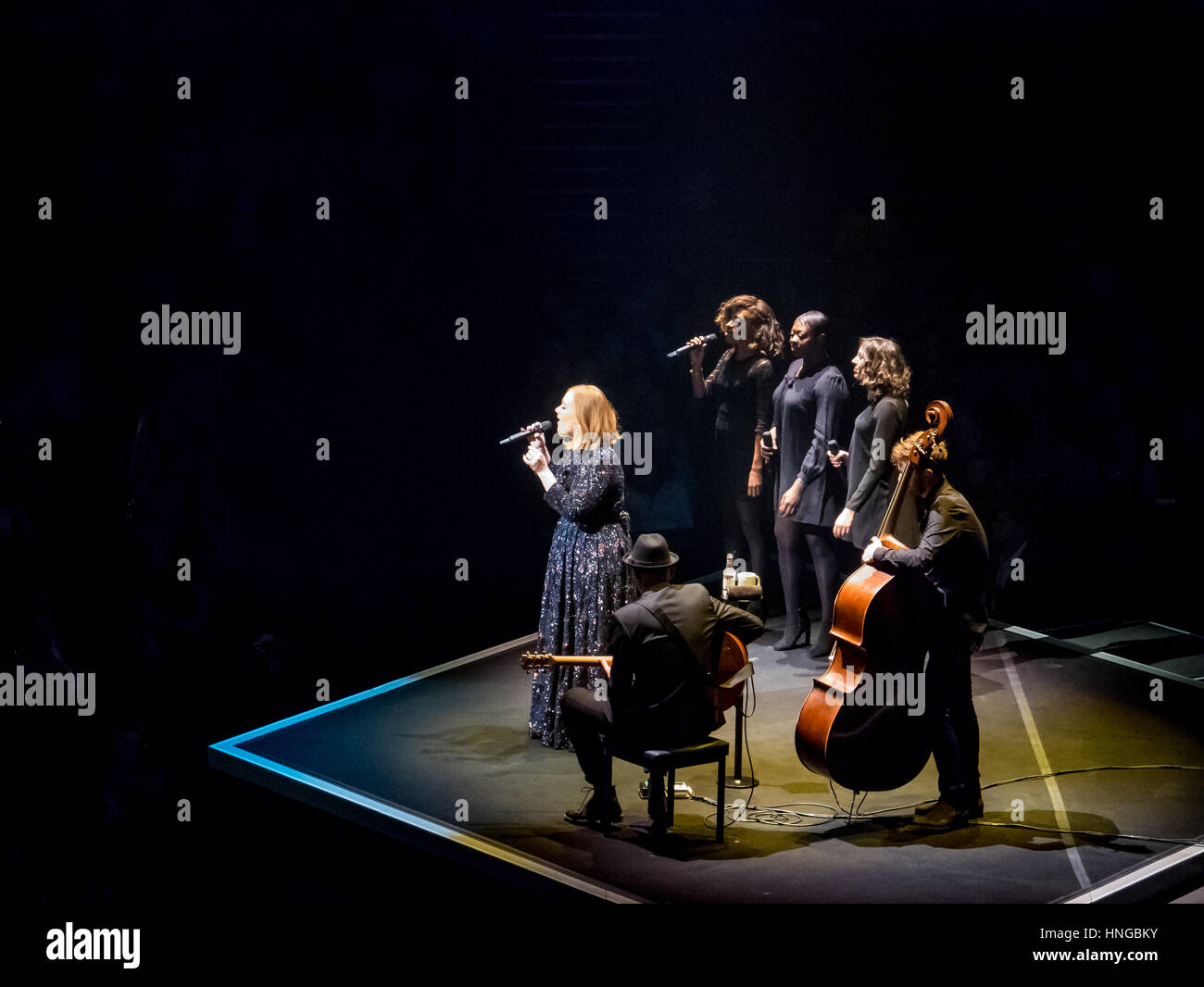 Adele in the spotlight with her band at Manchester Arena Stock Photo