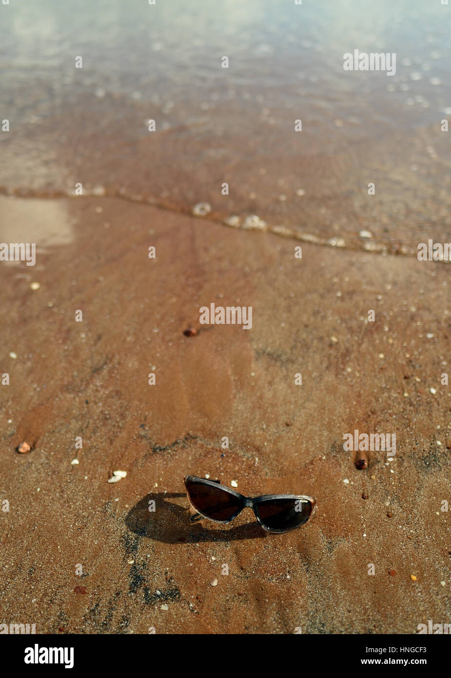 Sunglasses washed up on the beach. Stock Photo