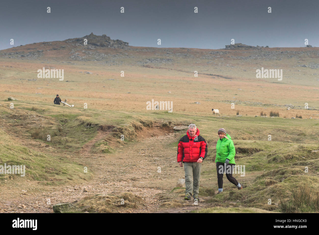 A couple of walkers on Rough Tor, designated as an area of Outstanding Natural Beauty on Bodmin Moor in Cornwall, England, UK. Stock Photo