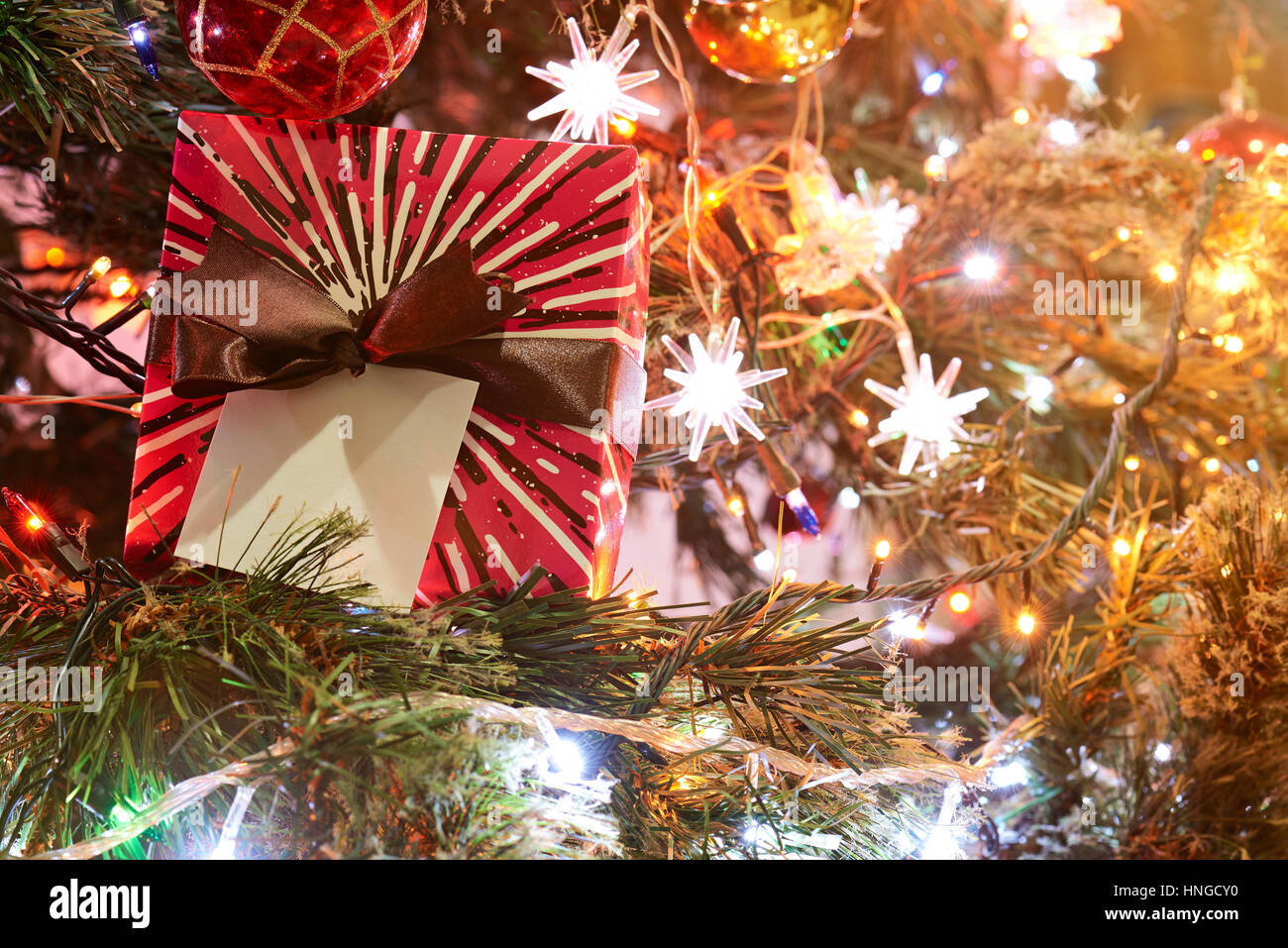 red present box with brown ribbon on christmas blurred light background Stock Photo