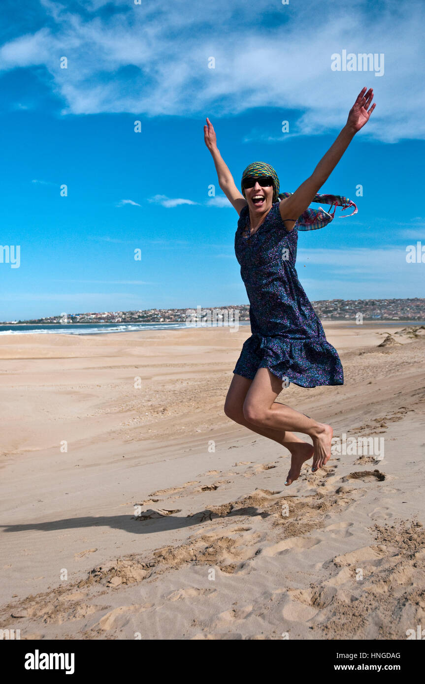 female on the beach jumping with joy Stock Photo